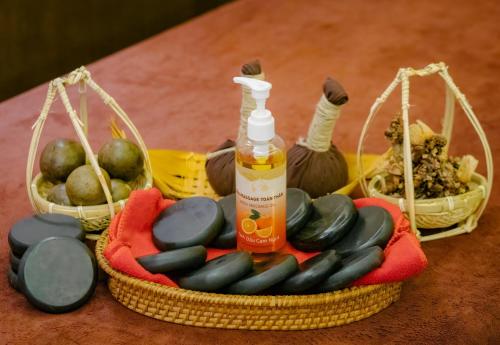 a basket with a bottle of oil next to some fruit at The Art Nest Hotel Nha Trang in Nha Trang