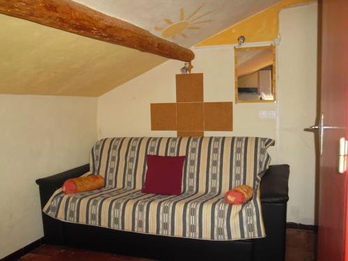 - un salon avec un canapé rayé dans l'établissement Petit Studio climatisé Lamalou - IMPORTANT lire les détails sous le poste VOTRE HOTE avec photo, à Lamalou-les-Bains