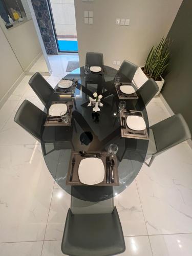 a glass table with chairs and a tableasteryasteryasteryasteryasteryasteryasteryastery at فندق الراية الفندقيه in Jazan