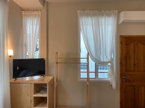 ein Wohnzimmer mit einem TV und einem Fenster in der Unterkunft Rivera 105 Vacation Home in Kathun