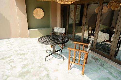a table and two chairs in a room with a patio at Bambuu Lakeside Lodge in Hazyview