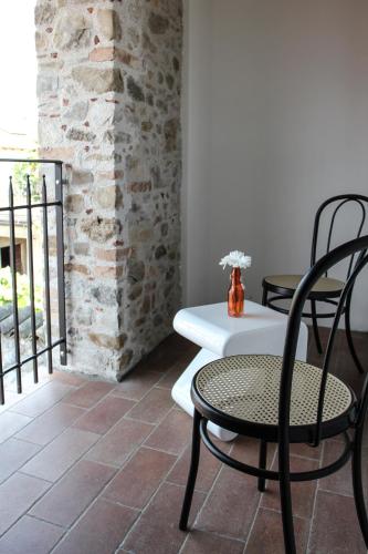 a table and chairs in a room with a brick wall at Al Sa di Te in Udine