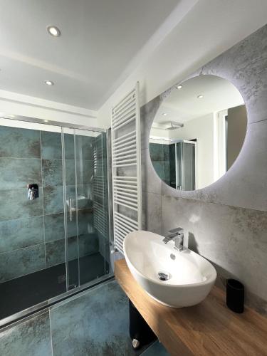 a bathroom with a sink and a shower and a mirror at Cà di Cambret with lake View in Stresa