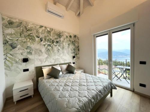 een slaapkamer met een bed en een groot raam bij Cà di Cambret with lake View in Stresa