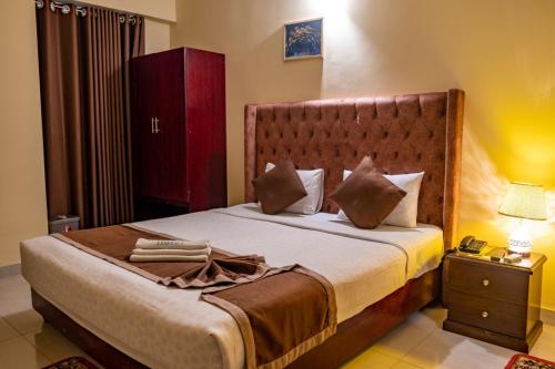 a bedroom with a large bed with a wooden headboard at Hotel Beach Park in Cox's Bazar