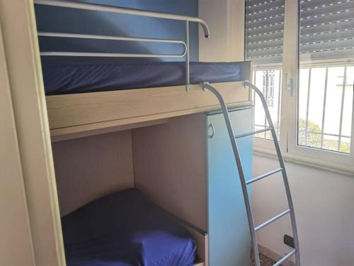 a bunk bed with a ladder in a bunk room at La piccola oasi tra sole e mare in Ceriale