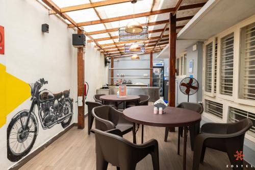 Zostel Bangalore- Indiranagar في بانغالور: مطعم على الطاولات والكراسي ودراجة على الحائط