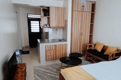 una camera con letto e una cucina con divano di Premier Stays Ruiru a Ruiru