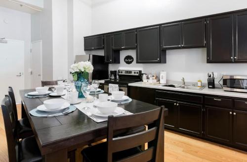 a kitchen with a dining table with black cabinets at Gaslamp 2bdrm1ba - W Parking & 4 Beds #304 in San Diego