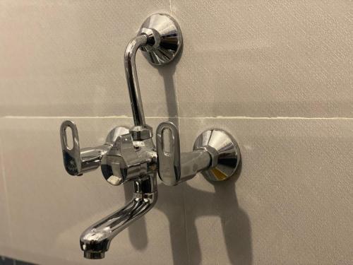 a metal faucet attached to a wall at La Tamara Luxury - TIE Hotels & Resorts in Pondicherry