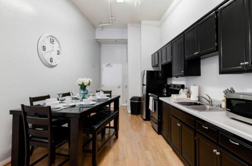 a kitchen with a table and a clock on the wall at Gaslamp 2bdrm - W Parking & 4 Beds #304 in San Diego