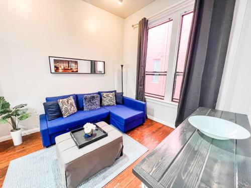 a living room with a blue couch and a table at Gaslamp 2bdrm1ba - W Parking & 4 Beds #304 in San Diego