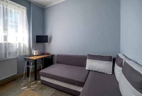 - un salon avec un canapé et une table dans l'établissement Noclegi pokoje gościnne Żeglarz, à Gdynia