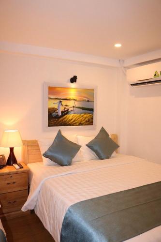 a bedroom with a bed and a painting on the wall at Saigoneer Hotel in Ho Chi Minh City