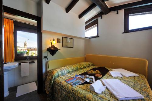 ein Schlafzimmer mit einem Bett, einem Waschbecken und einem Fenster in der Unterkunft La Torre Di Porlezza in Porlezza