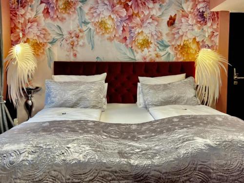 a bedroom with a large bed with a floral wallpaper at Boutique Hotel & Bio Wirtshaus Schwarzer Bock in Ansbach