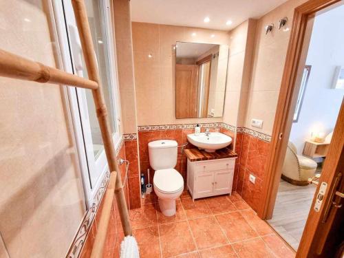 La salle de bains est pourvue de toilettes, d'un lavabo et d'un miroir. dans l'établissement Aguadores del Pilar ComoTuCasa, à Saragosse
