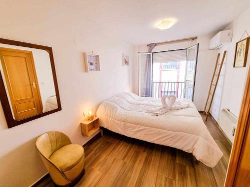 - une chambre avec un lit, une chaise et un miroir dans l'établissement Aguadores del Pilar ComoTuCasa, à Saragosse
