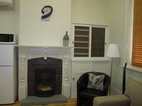 sala de estar con chimenea y silla en Clydesdale Cottage B&B, en Maitland