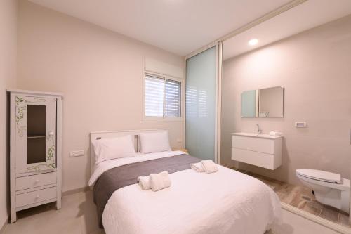 a bedroom with a bed and a sink and a toilet at דירת נופש מרחבים Merhavim Villa in Shadmot Devora