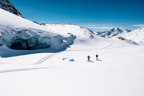 マソ・コルトにあるAparthotel Maso Cortoの雪山を滑り降りる二人
