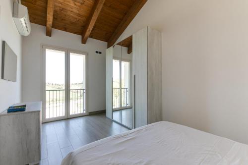 a bedroom with a bed in a room with windows at Bio Fattoria Mula D'Oro - biofattoriamuladoro it - Organic Food, Nature & Relax in Mulazzano