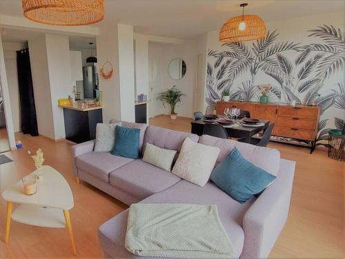 uma sala de estar com um sofá roxo e uma mesa em Le cocon vitréen ! em Vitré