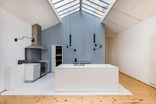 una cocina con una isla blanca en una habitación en Zeus loft 400m² 6rms 6BR hypercentre, en Saint-Étienne