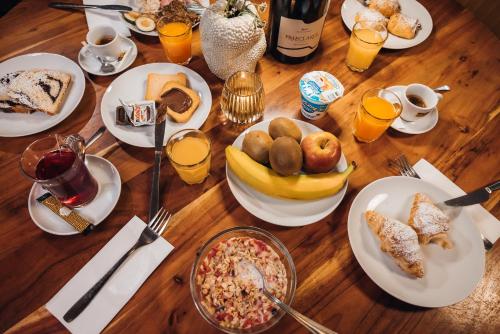a wooden table topped with plates of breakfast foods at Aparthotel Maso Corto in Maso Corto