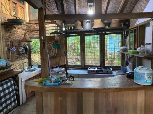 a kitchen with a counter and some windows at Villa Cetok Syariah - Nuansa Pedesaan in Simpen