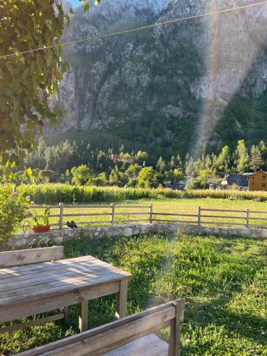 a wooden picnic table in a field with a rainbow at Guesthouse Gezim Selimaj in Valbonë