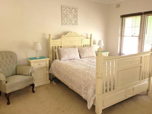 een slaapkamer met een wit bed en een stoel bij Prospect Place in Prospect