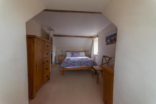 1 dormitorio con cama y tocador de madera en Traditional Cotswold Stone Peaceful Cottage with stunning views, en Stroud