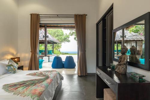 1 dormitorio con cama y espejo grande en Villa Sheeba, en Pengastulan