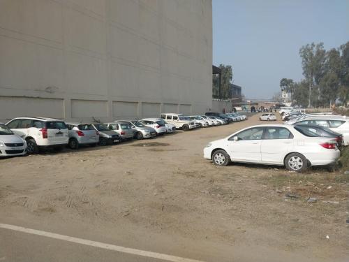 a bunch of cars parked in a parking lot at Hotel Dara Royale in Amritsar