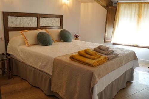 een slaapkamer met een bed met handdoeken erop bij La Casita de los Pájaros in San Martín de Valdeiglesias