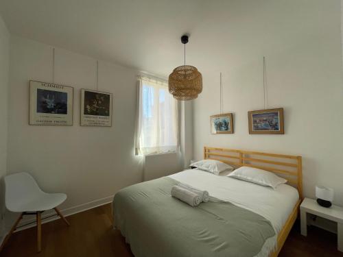 une chambre avec un grand lit et une chaise dans l'établissement Le Virtuose - Dans l'hypercentre de Toulouse, à Toulouse