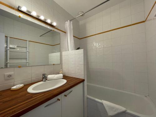 une salle de bain avec un lavabo, une baignoire et un miroir dans l'établissement Le Virtuose - Dans l'hypercentre de Toulouse, à Toulouse