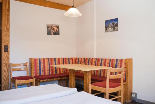 a room with a table and chairs and a bench at Aparthotel Maso Corto in Maso Corto
