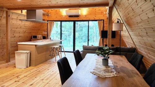 a kitchen and dining room with a wooden table and chairs at Kitagi Cabin in Hakuba