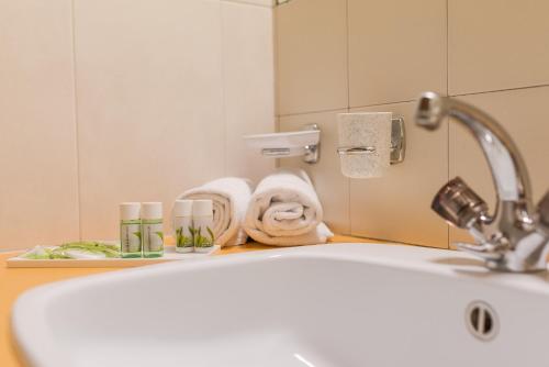 a bathroom with a sink and towels on a counter at Aparthotel Maso Corto in Maso Corto