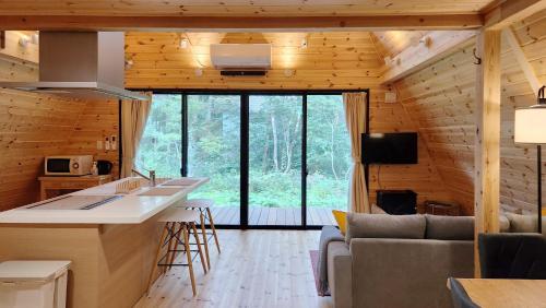 a kitchen and living room in a log cabin at Kitagi Cabin in Hakuba