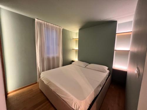 - une petite chambre avec un lit blanc et une fenêtre dans l'établissement LA DIMORA DEI MORI, à Catane