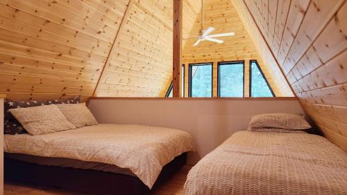 a bedroom with two beds and a ceiling fan at Kitagi Cabin in Hakuba