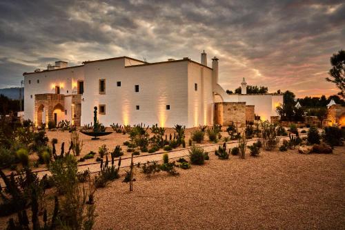 a large white building with plants in front of it at Bambarone La Masseria in Fasano