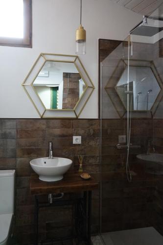 een badkamer met een wastafel en een spiegel bij La Casita de los Pájaros in San Martín de Valdeiglesias