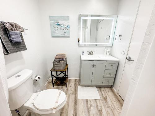 a bathroom with a white toilet and a sink at Gaslamp 2bdrm - W Parking & 5 Beds #303 in San Diego