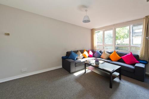 a living room with a couch with colorful pillows at ALTIDO Spacious apt with private yard in Notting Hill in London
