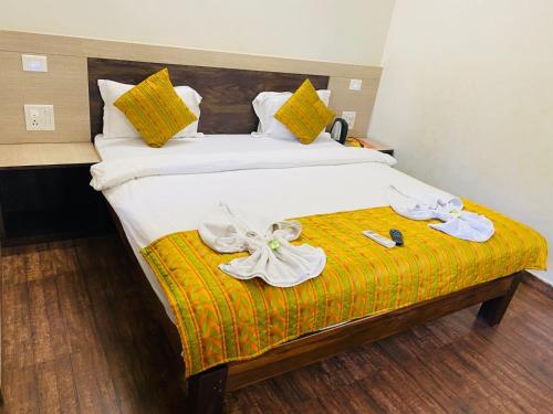 una habitación de hotel con una cama con zapatos. en Baga Beach Inn en Baga
