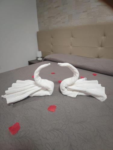 two swan towels on the floor of a bedroom at Piazza Dante in Taranto